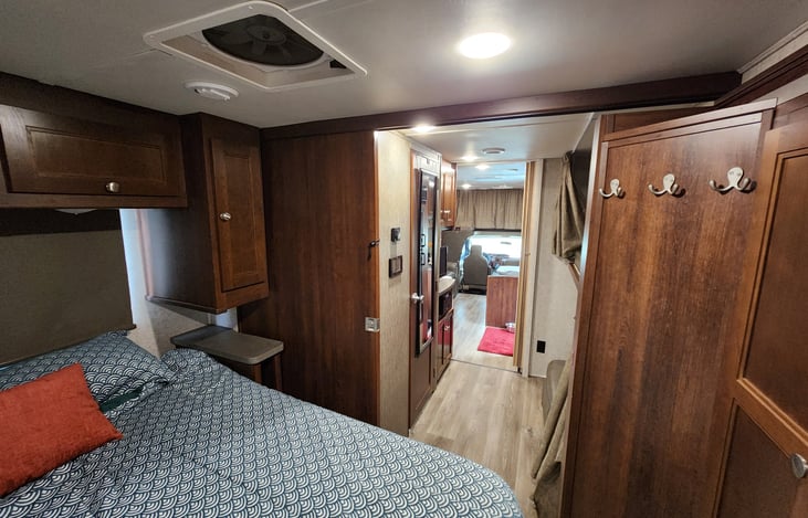 Rear bedroom with queen bed, TV and wooden sliding door.  Also has blackout shades to keep things dark when trying to get some rest.