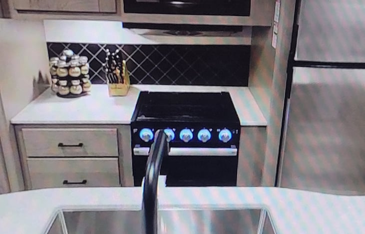 kitchen area, 3 eye stovetop, oven, refrigerator, freezer, microwave, storage cabinets, island sink