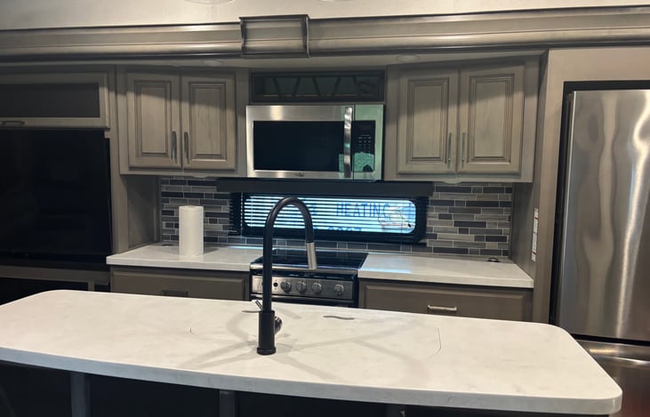 Large island in the kitchen with a convection oven and microwave and stove