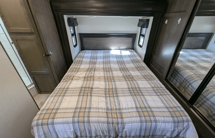 Bedroom has a slide-out creating extra space and comfort. Cozy Queen bed and ample natural light and storage.