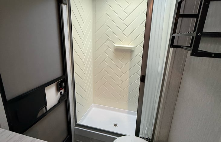 Walk-in shower with skylight, plus toilet