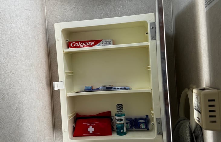 Above the sink cabinet to be used for your toiletries, and it also offers a mini first aid kit.