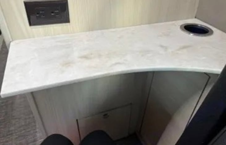 Small laptop desk with power and cup holder behind drivers seat.