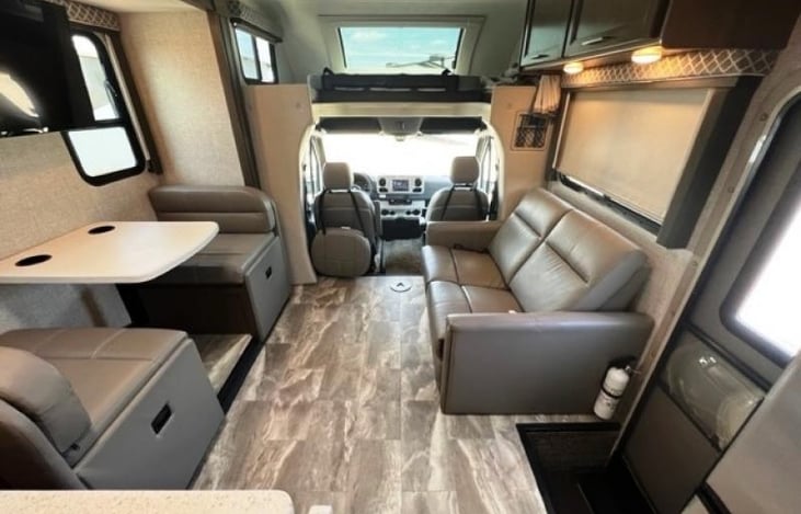 View of the living and dining space from the kitchen area. Another small table can be added and captains chairs swivel around to offer more seated dining space.
