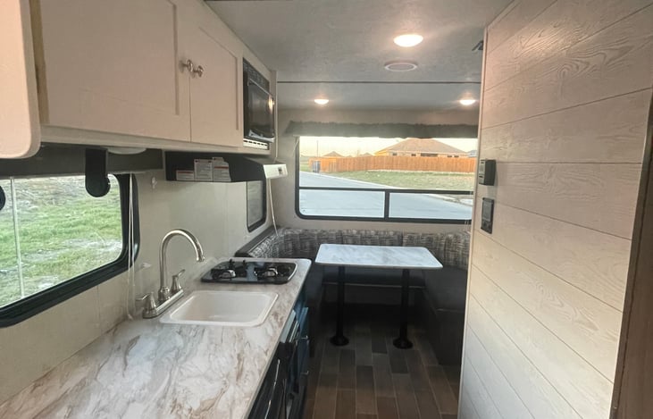 Kitchen and dinning area. Kitchen has fridge, stove stop, microwave, sink, and a 4 set of dinning wear.