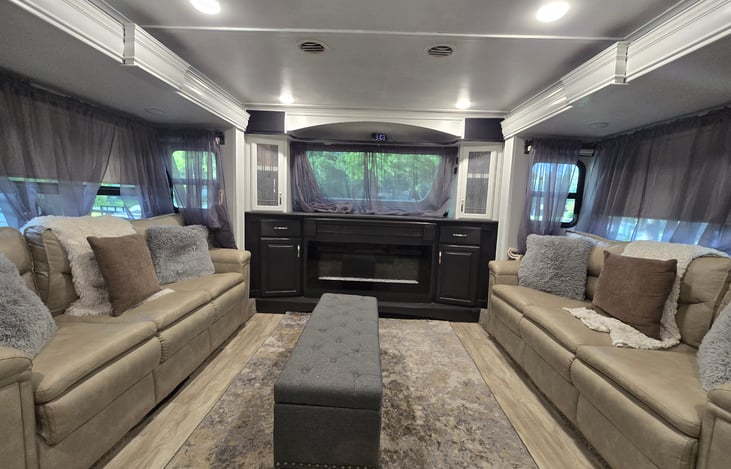 Front living room with two sofas that pull out into beds, two automatic recliners, and a Televator (hidden TV)