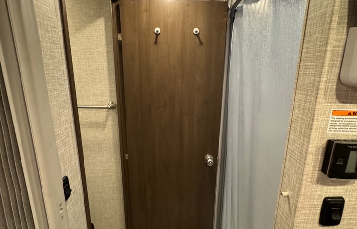 View from bedroom looking towards bathroom with the door extended as a divider making this a connected suite with privacy from the common areas.