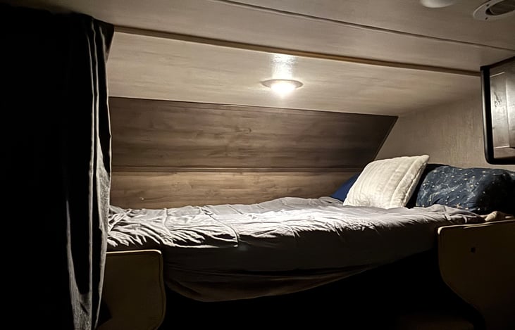 Queen Bed over cab features lighting, window, and a privacy shade