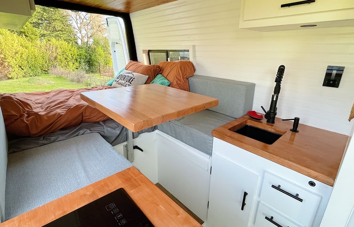 Multiple set up options for living space. Partially made bed allows for dining, lounging, working, reading with Lagun table.