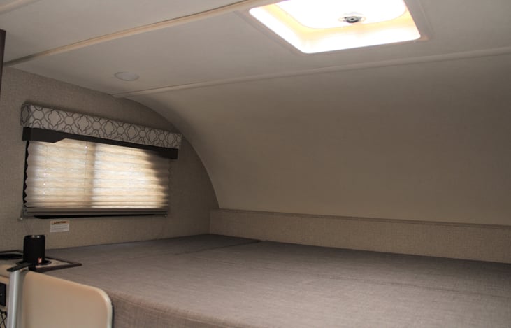 Double bed can sleep two adults, cupholders, and privacy curtain with easy access to the mesh charging station. Bedding can be added as an add-on.