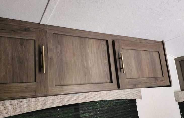 Cabinets over table has flashlights,  dishes, silverware, cups.