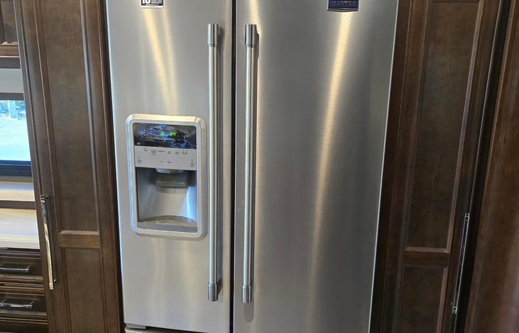 Full size side by side refrigerator with large freezer drawer, ice and water in the door.  Two pantry cabinets slide out for lots of storage