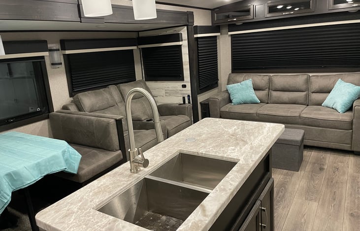 Rear of RV with two recliners and large couch that pulls out into a queen size bed.  Dinette also converts to a Single bed