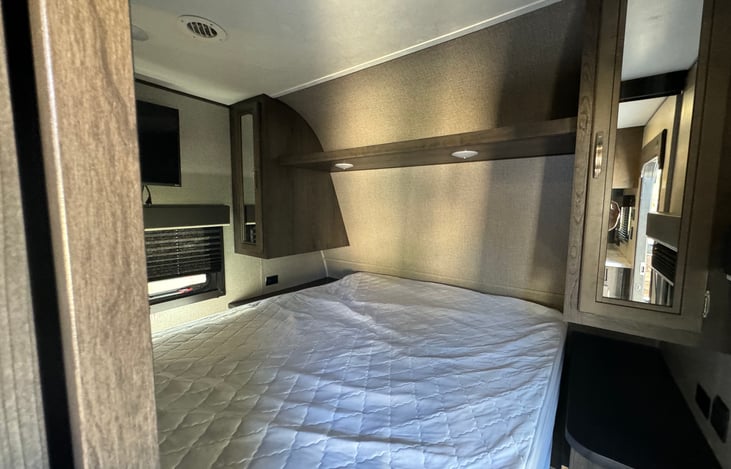 Queen master bedroom including 2 wardrobes, overhead storage, and 32" television.  Sliding doors for privacy.