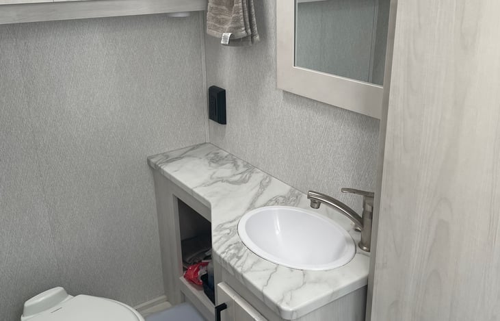 The bathroom is directly across from the shower, and has a door for privacy.