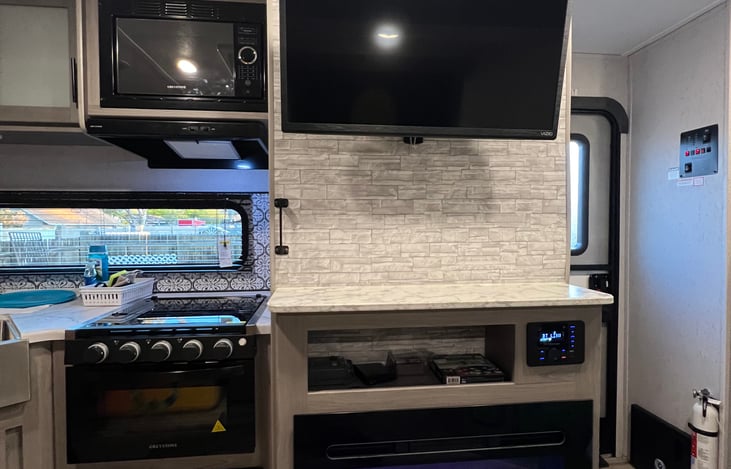 living room area , which includes fireplace, 32'' smart TV, 3 burner stove, microwave, and more !