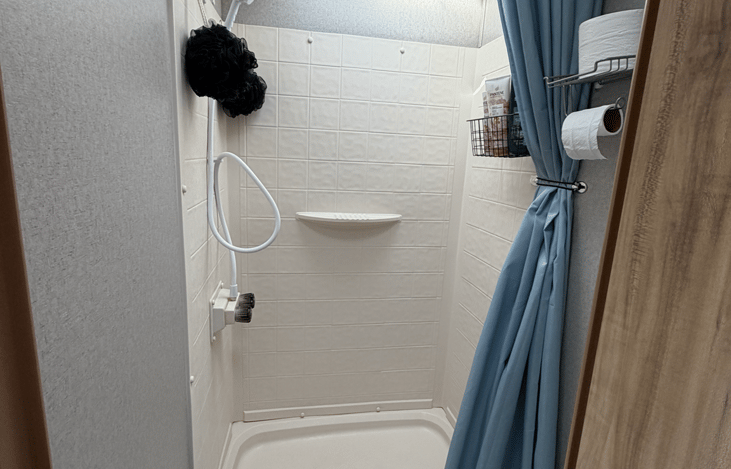Compact bathroom includes a shower and toilet for added comfort and convenience during your camping adventure.