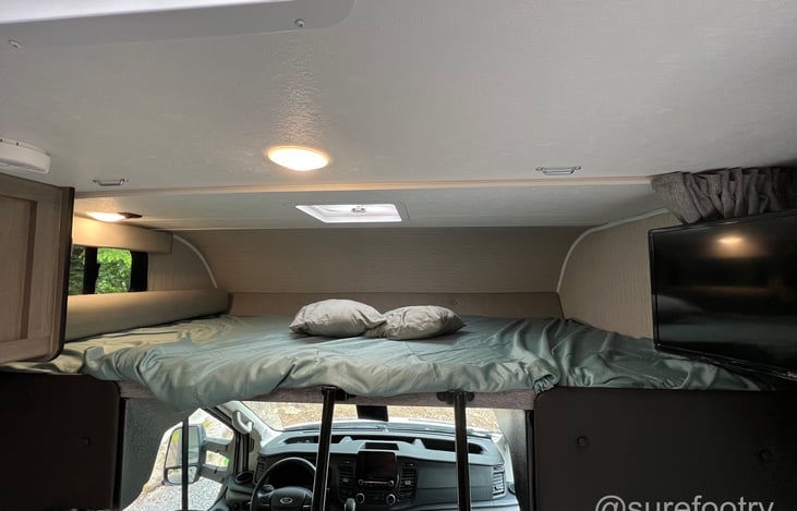 Overhead bunk bed can sleep between 1 - 2 adults.