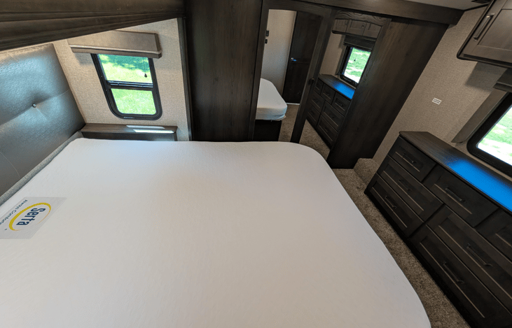 Private master suite with a queen bed, residential mattress, reading lights, deep dresser drawers, massive front wardrobe with hanging space, and washer/dryer prep. High-end restful comfort!
