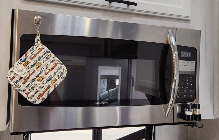 Residential-size microwave and salt and pepper shakers.