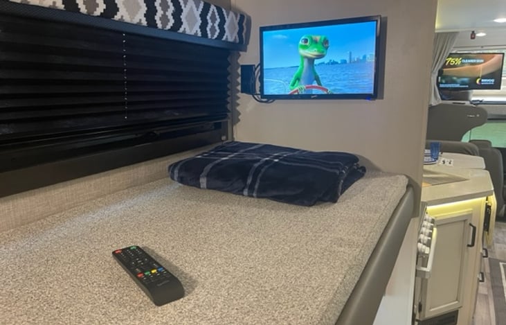 Top bunk bed with window and shade.