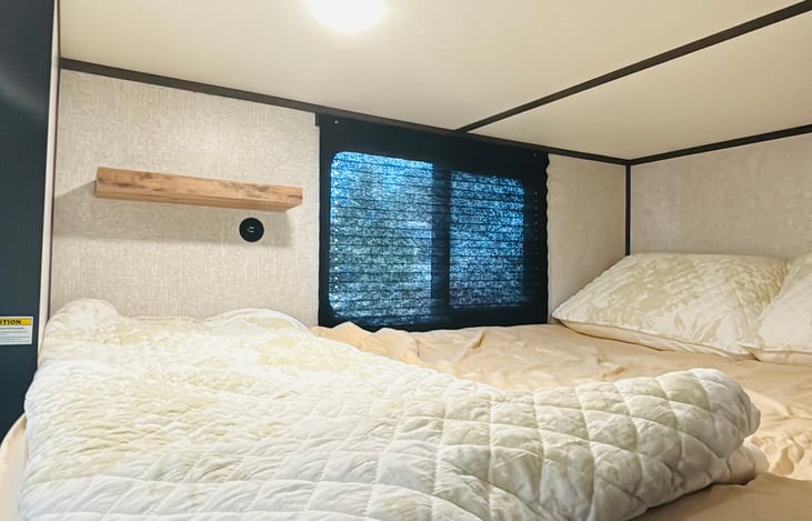 Full size bunk beds with phone charger and shelf.