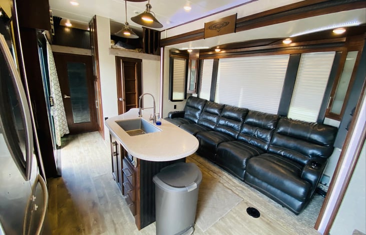 Reclining seating with 60” tv in living area. Two twin loft bunks overhead.