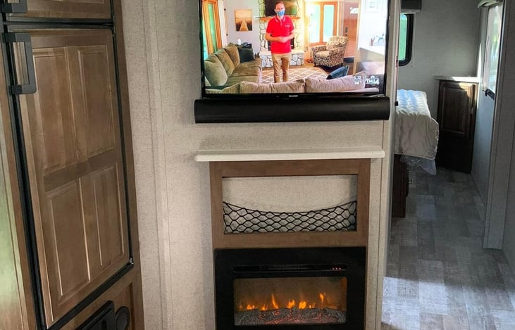 TV & Entertainment Center with Fireplace. Next to a refrigerator and freezer.