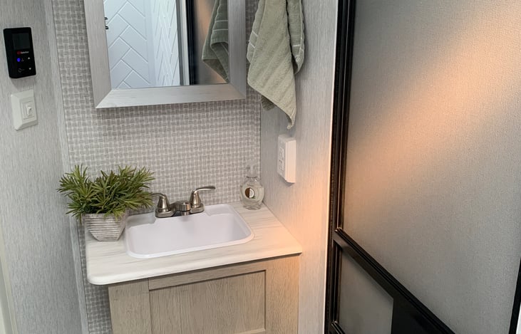 Single bowl sink with storage, also ample storage in the vanity mirror.