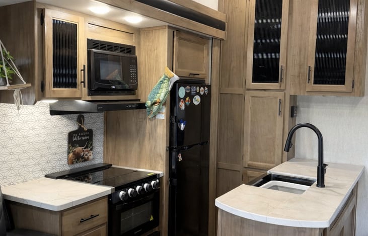 Designed for those who love to cook and entertain, the kitchen in this 2023 Arctic Wolf feels less like a camper and more like a luxury apartment. The open-concept design maximizes counter space.
