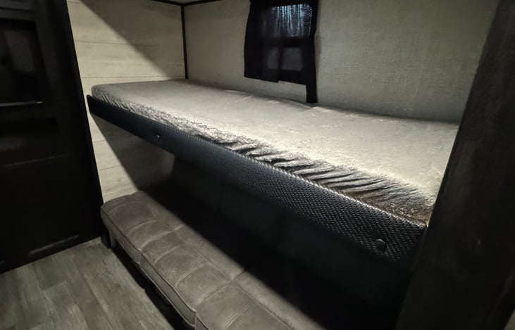 Single bed above a couch.  Couch can be laid flat for additional sleeping arrangements and single bed can be lifted for easy access to the couch.