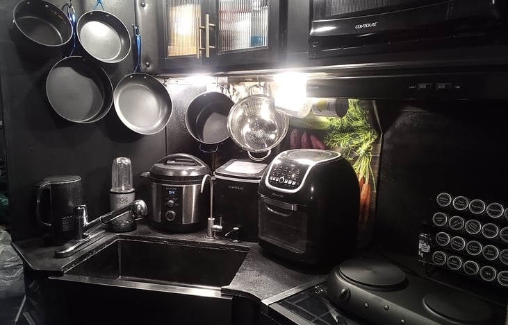 Newly remodeled modern looking kitchen with spice rack pots and pans and kitchen appliances. Pressure cooker ice maker air fryer tea kettle and blender