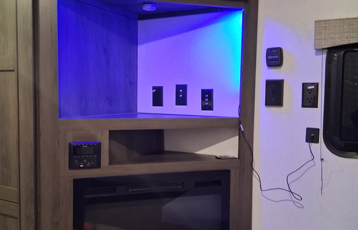 Electric fireplace and entertainment area with mood lighting.