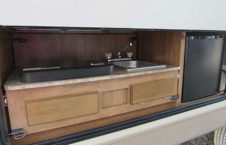 Outdoor kitchen with burner, sink and mini fridge