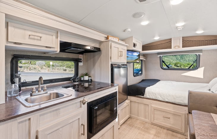 Kitchen sink, 3 burner stove, vent hood, convection oven and fridge.