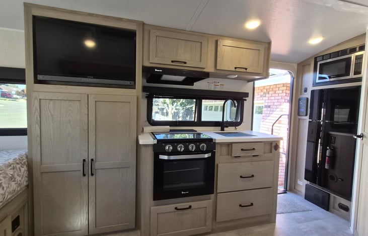 Stove with fan,  light, 3 burners, and oven.   

Refrigerator and freezer with microwave (right side of picture)