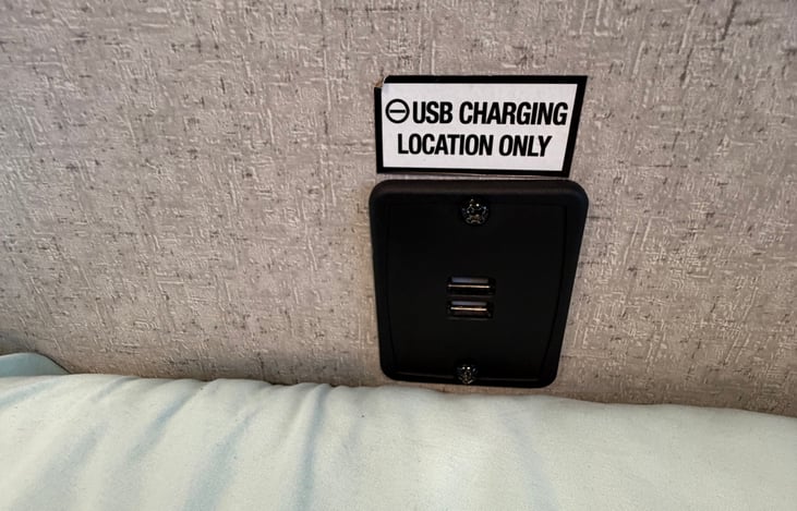 Convenient USB charging port near the bed for easy overnight phone and device charging.