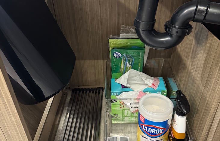 Trash bags and cleaning supplies under the kitchen sink.
