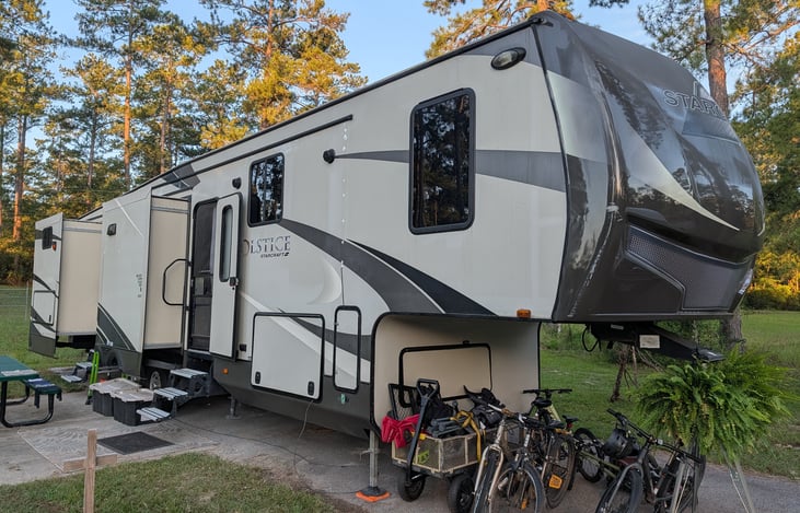 The front passenger side of the RV, front door, kitchen slide, and bunk slide. The bikes and garden cart are not included in the rental.
