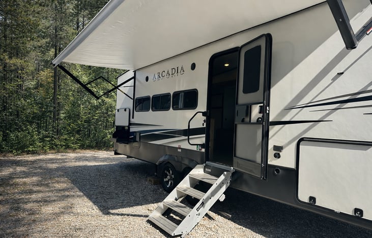 Solid entry steps with wide door access and power awning for shaded outdoor living space at your campsite.