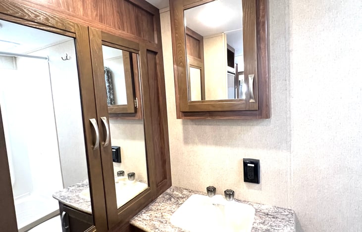 Large storage cabinet in bathroom with towels but room for your items as well.