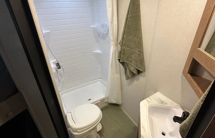 3 Piece bathroom with towels, toilet paper, supplies
