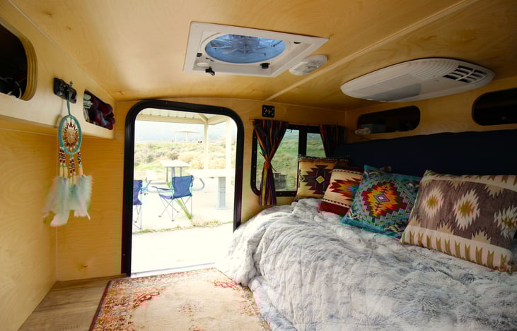 The beg conveniently folds into a couch for day use. This makes storing things in the trailer easier. Shown is our glamping bedding option.