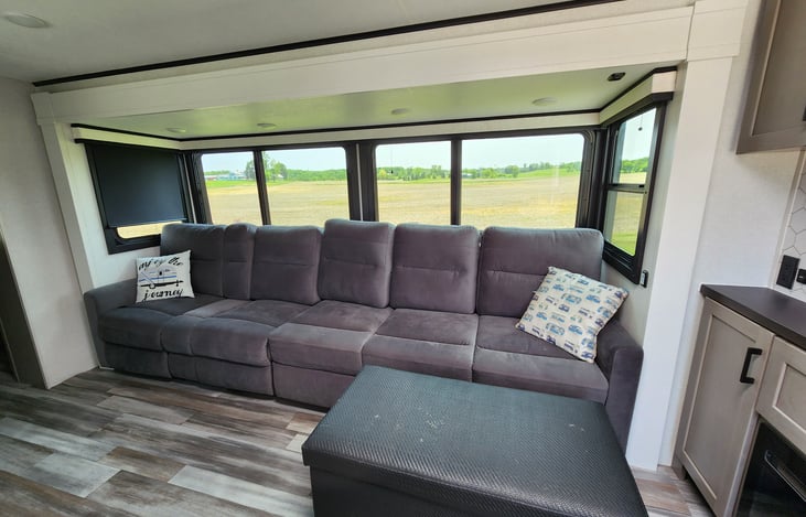 Mega Lounge Sofa. Left 2 chairs are recliners with fold down arm rest with cup holders, and right 3 seats fold out to a bed.