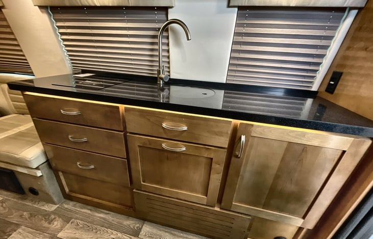 Full kitchen with induction cooktop, spacious refrigerator, Keurig,  and convection microwave.