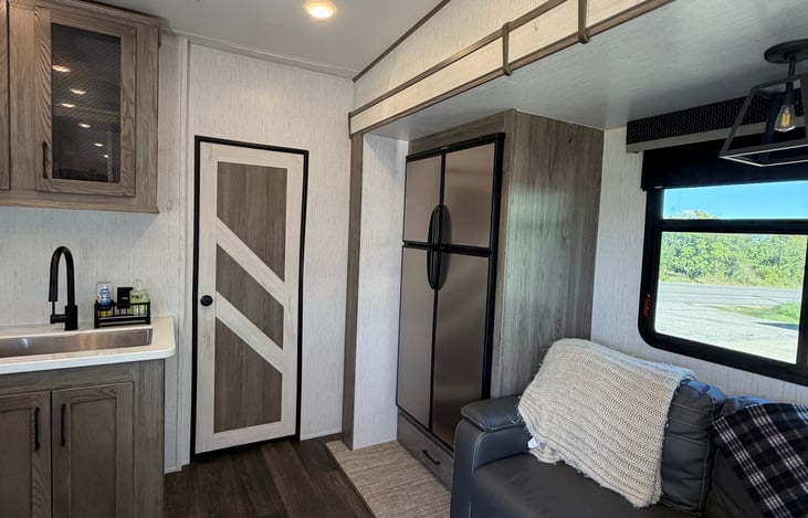 Rustic wood accents, charming farmhouse details, and comfortable seating make this fifth wheel feel like home.