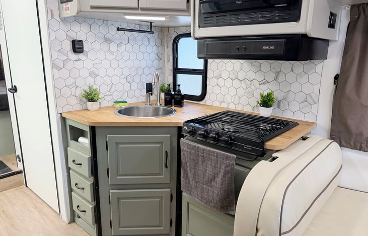 Fully equipped RV kitchen with stove, sink & storage – everything you need for your camping adventure