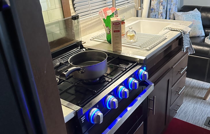 Stove is a three burner gas/propane wonder! The oven small but mighty. 2 lights a soft back light as well as well as a blue glow to light up knobs. Backlight also makes a great nightlight.