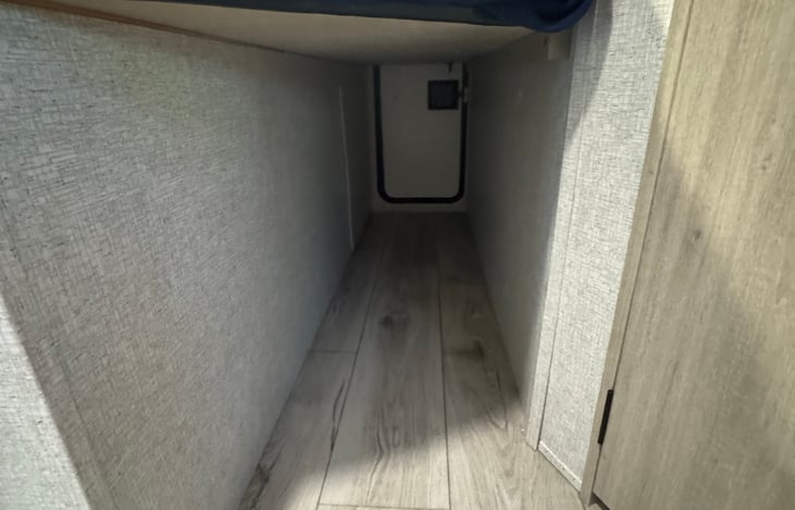 Under bunk pass through storage. Half of the bottom bunk lifts up for taller items.