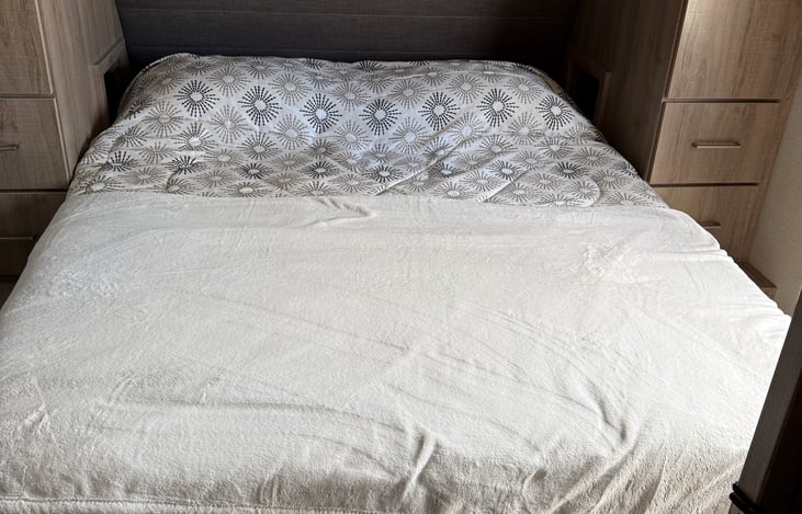 This is the comfortable Queen Bed, regular size (not thin RV size). It's very comfortable, with cubby holes for phone and C-Pap if needed. Plenty of storage for clothes on the side and top.